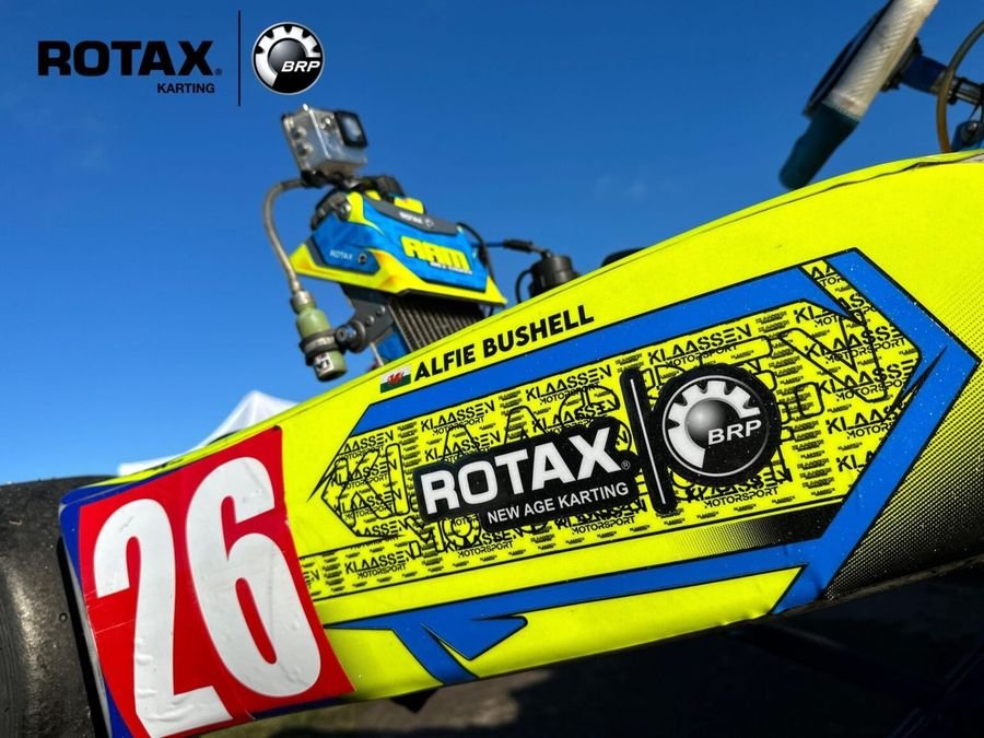 A Rotax-powered Klaassen Motorsport kart in fluorescent yellow and blue, race number 26.